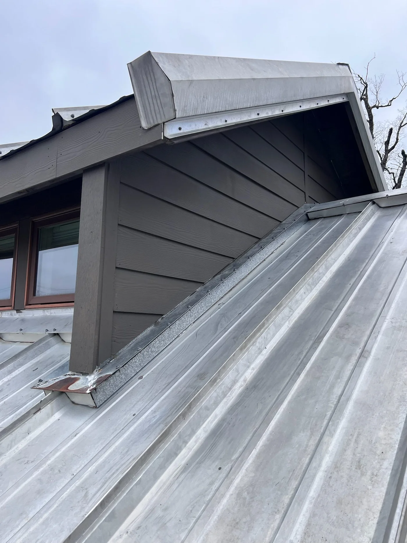 Standing-seam metal roof dormer detail with new flashing