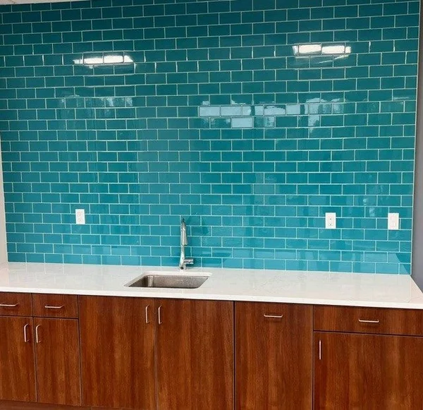 Commercial break room wet bar with teal subway tile and walnut cabinets