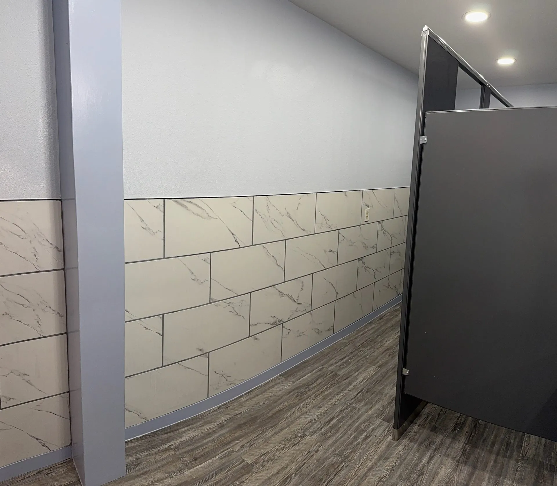 Marble subway tile wainscot in commercial restroom