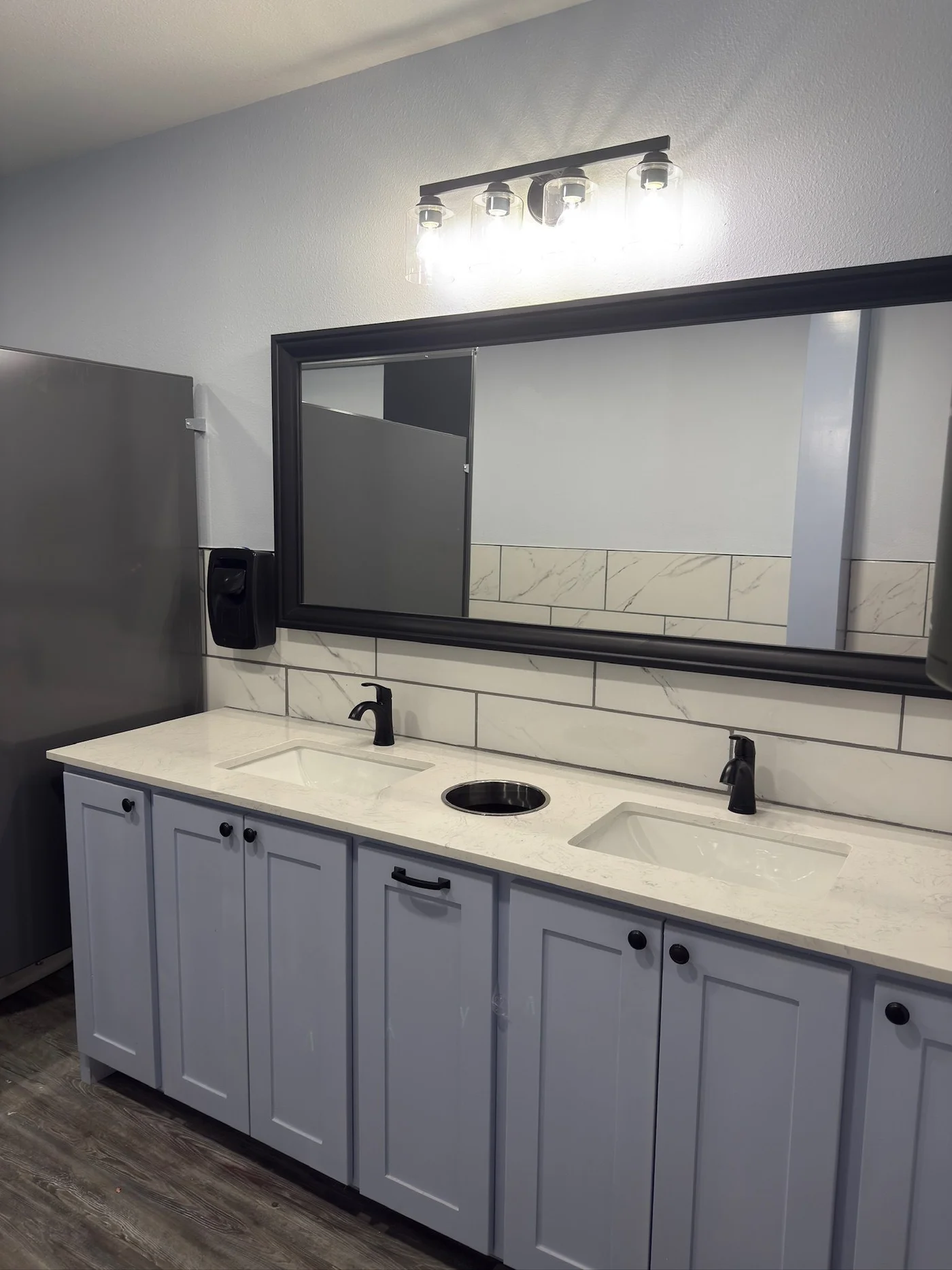 Commercial double vanity with marble subway backsplash and gray shaker cabinets