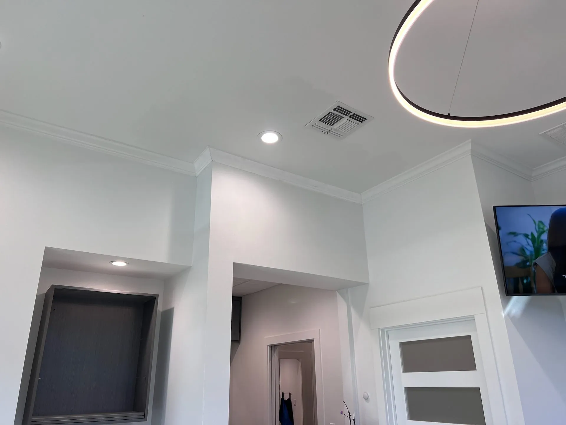 Coffered ceiling with crown molding and modern ring pendant light