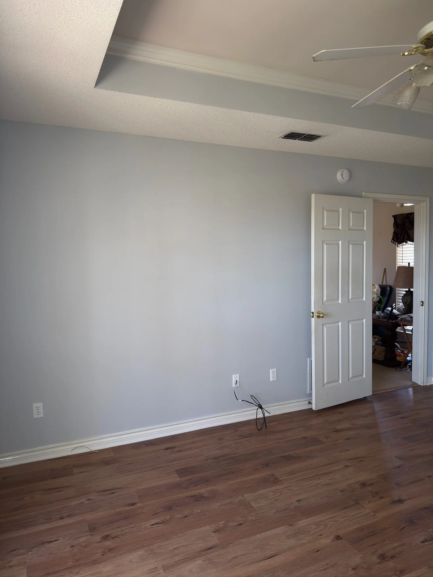 Grey painted bedroom with open door to adjoining office