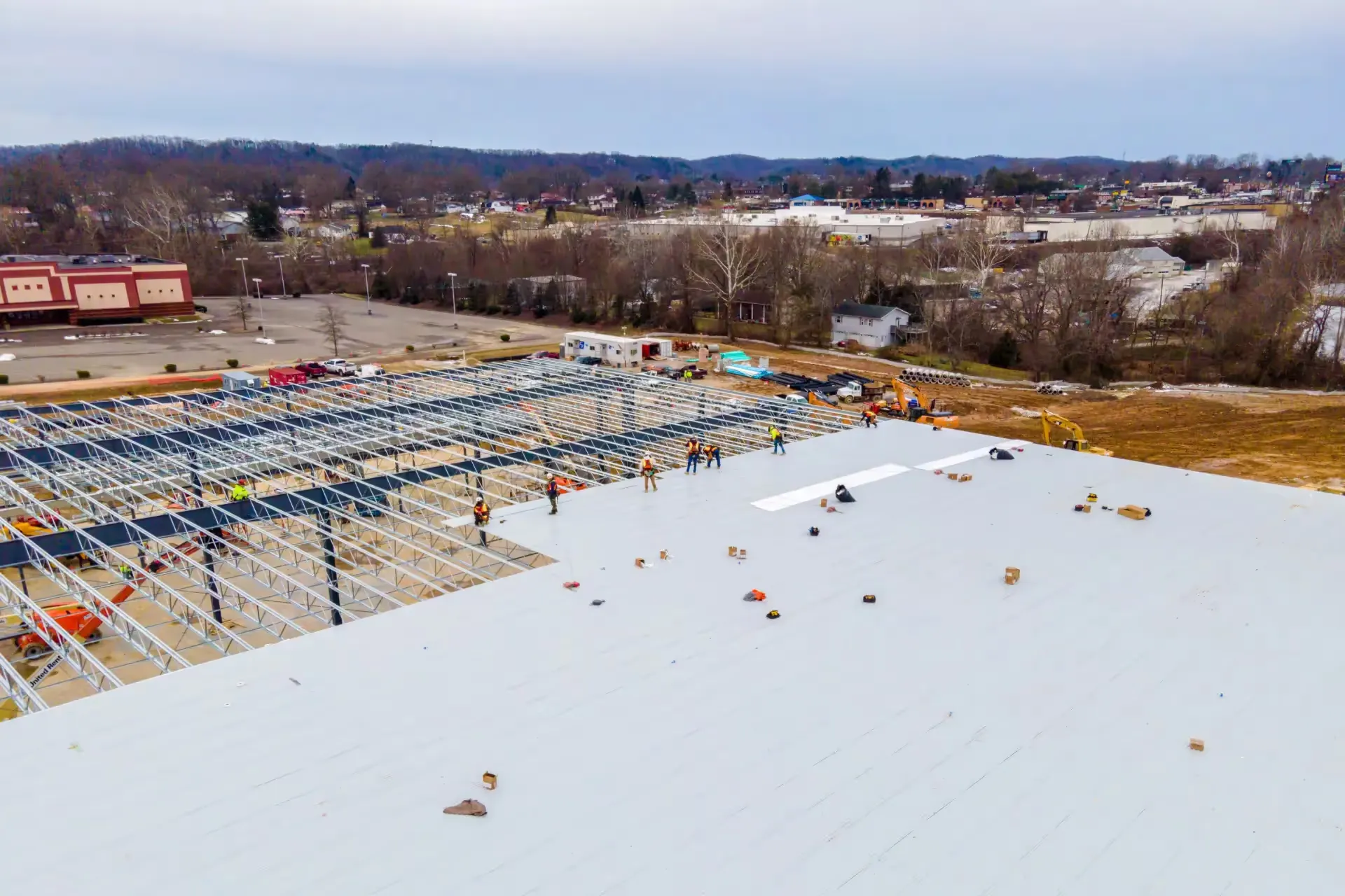 Aerial view of construction workers on a commercial building rooftop