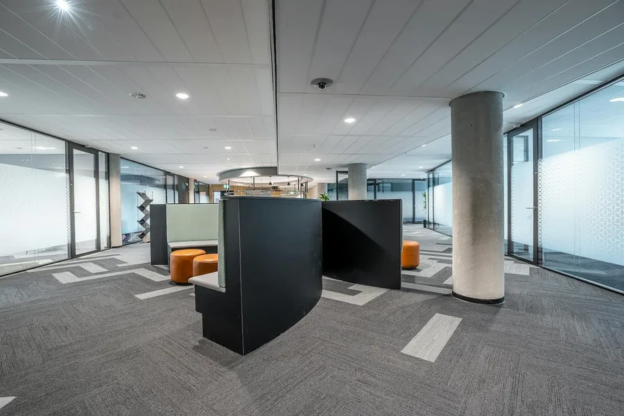 Open finished commercial interior build-out with a reception desk and structural columns