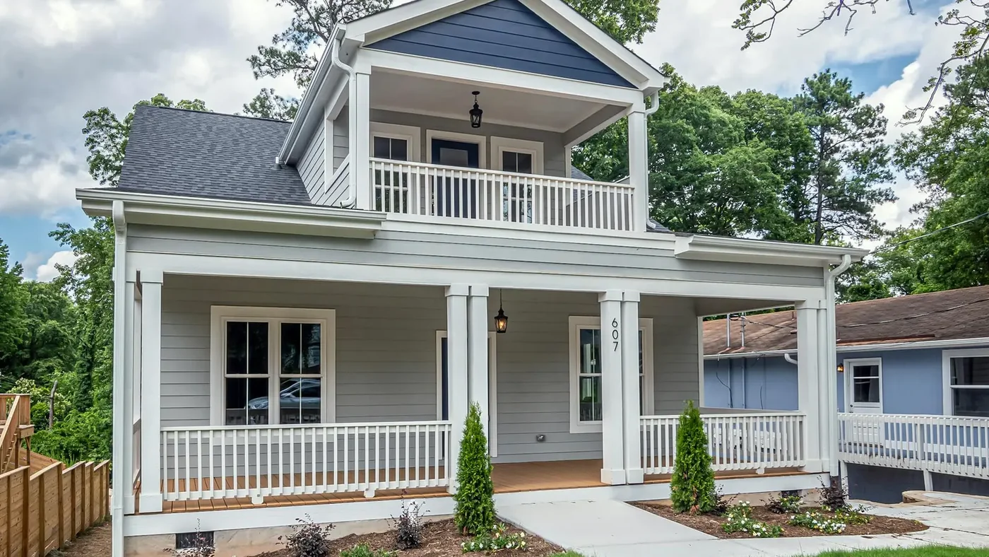 Light gray Craftsman-style home with a full front porch, tapered columns, and a second-story balcony
