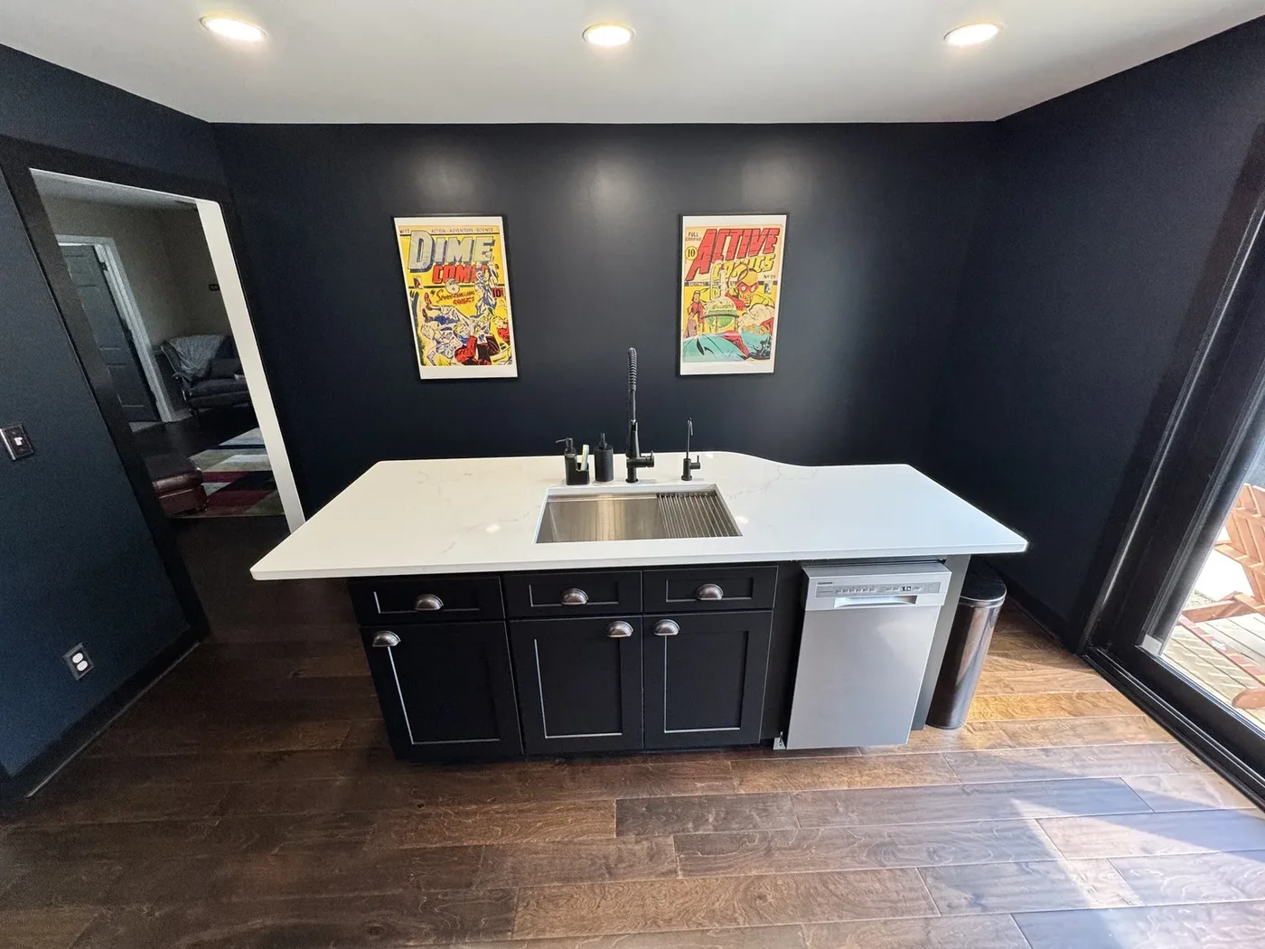 Custom home kitchen with a white waterfall island and dark cabinetry