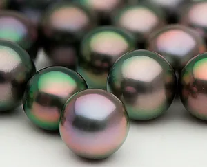 Close-up of round dark Tahitian pearls with green, pink and peacock overtones