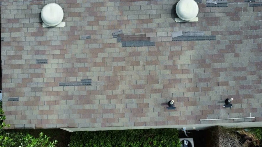 Close-up of the old, weathered shingles and vents before replacement
