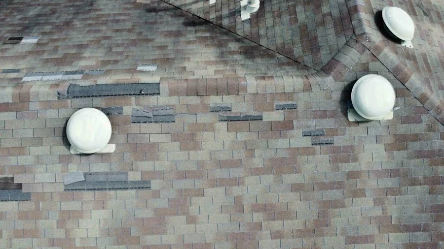 Storm-damaged shingles around the roof vents before the new roof