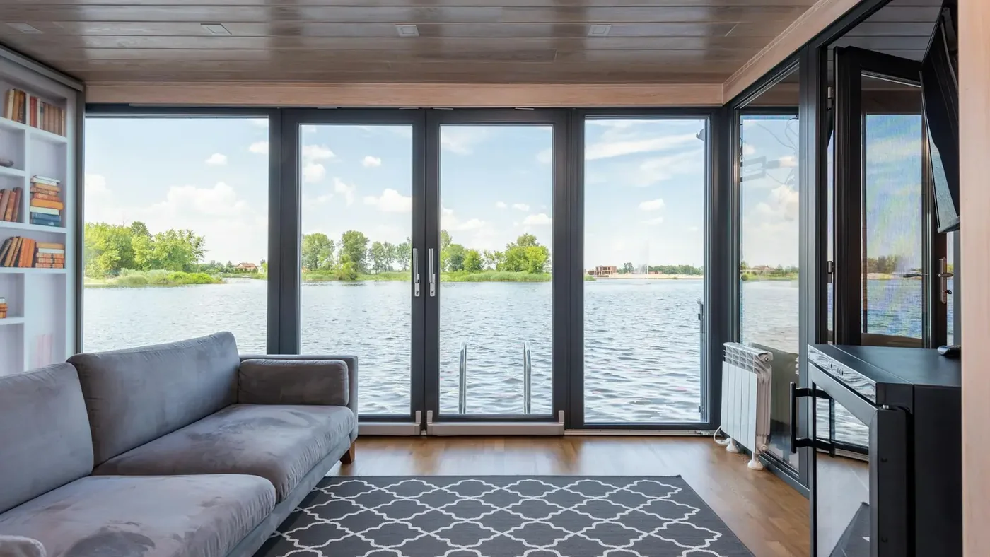 Floor-to-ceiling windows in a lake house living room with an open view of the water