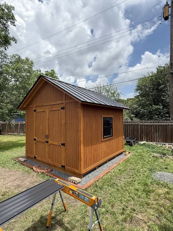 Backyard shed with its new black metal roof
