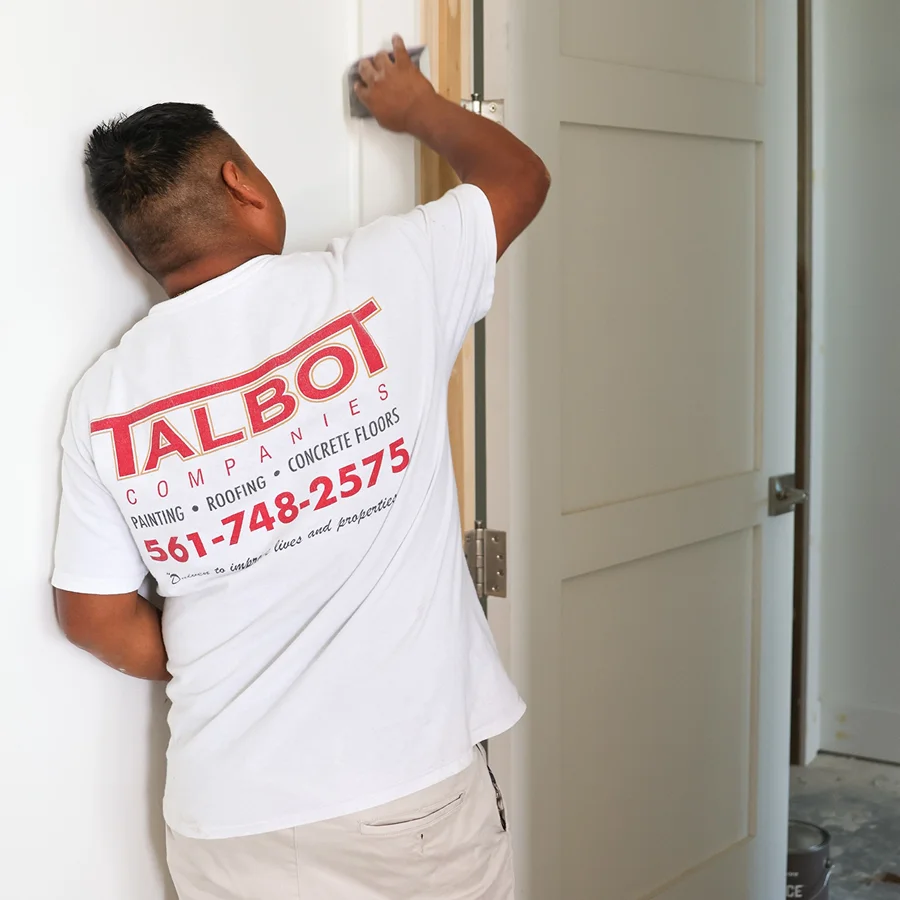 talbot painter working on a door frame