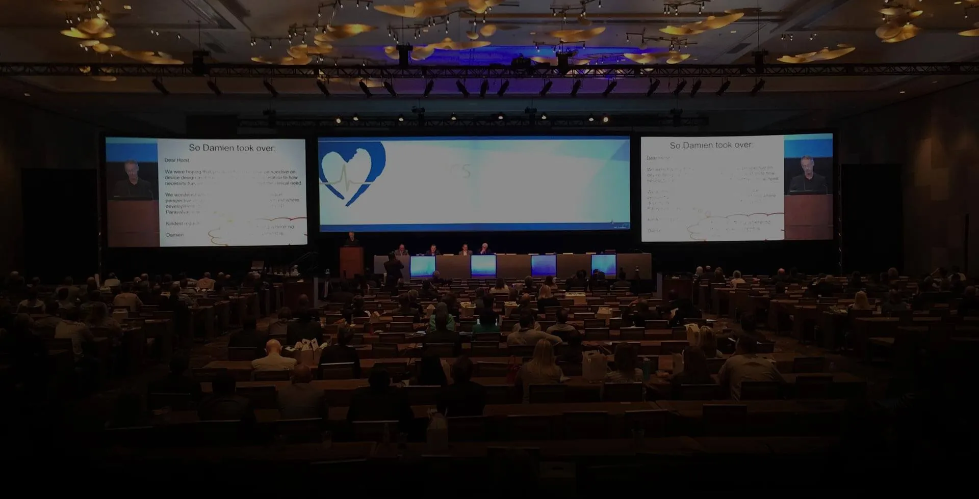 A ballroom general session with a wide multi-screen projection blend