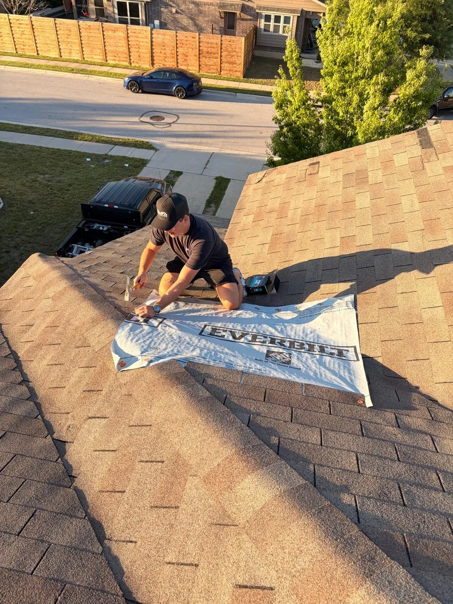 Will Christensen of Kind Roofing tarping a storm-damaged roof