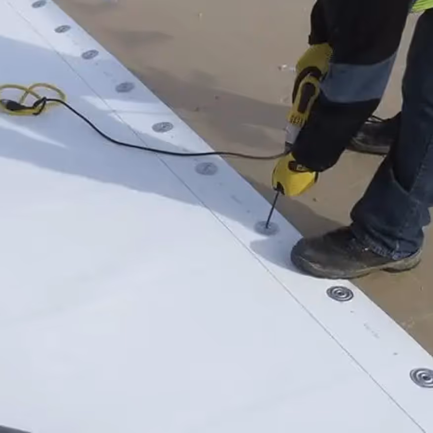 A crew welding a TPO commercial roof seam